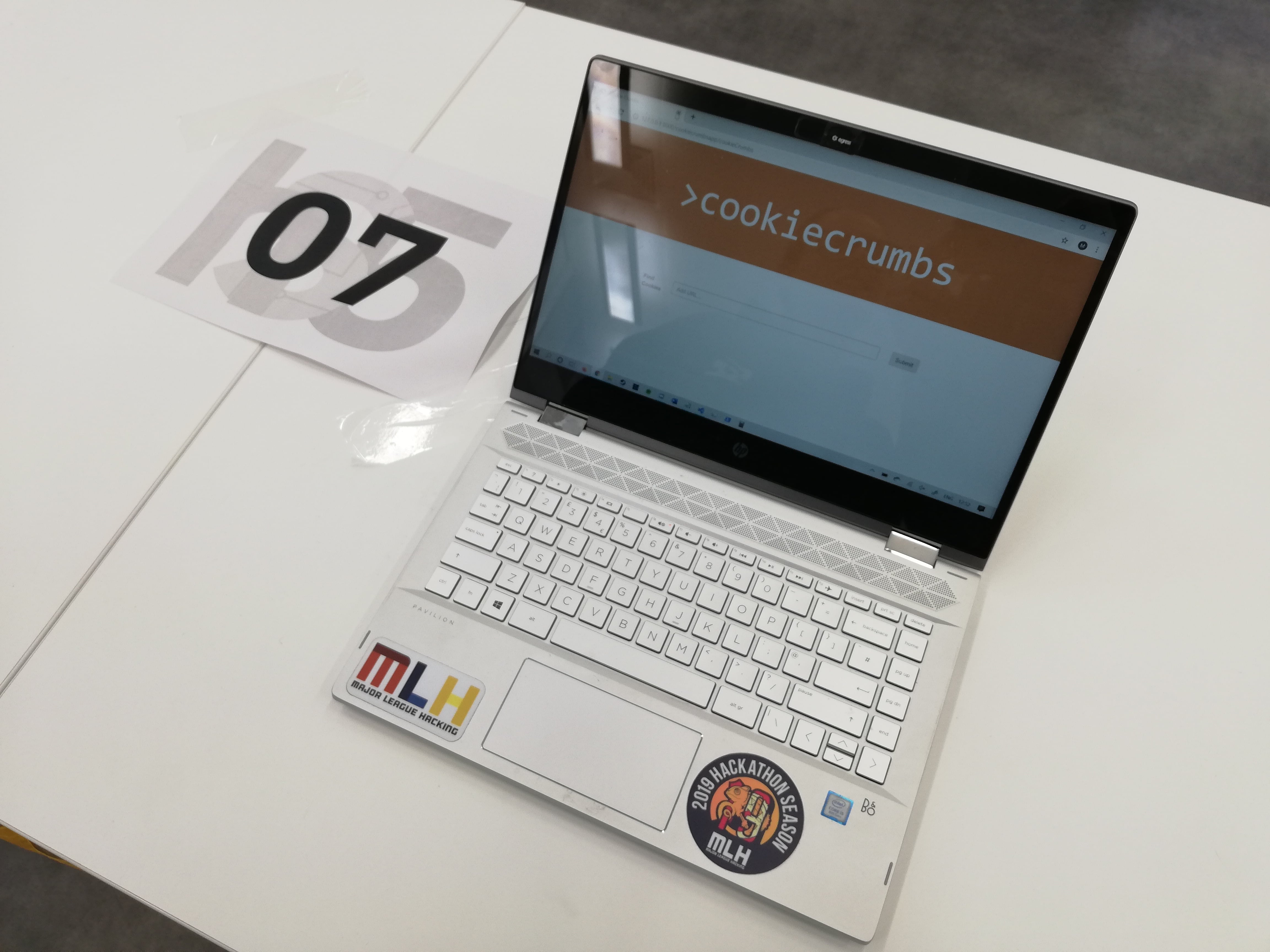 A laptop on a table, displaying a website called 'Cookie Crumbs'